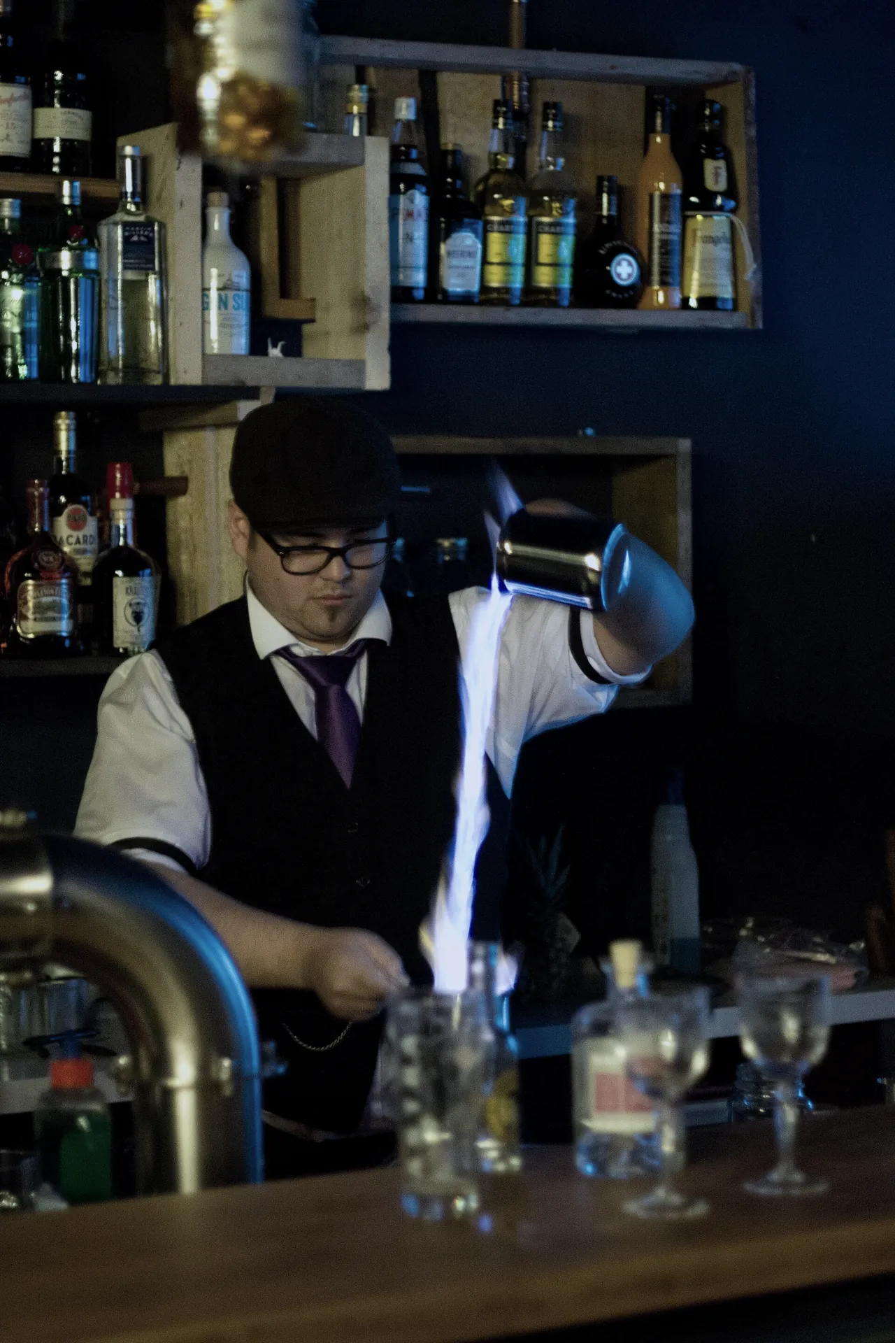 ブルーブレイザーを作るバーテンダー。火のついた酒をカップからカップへ移す
